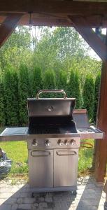 a grill sitting on a patio in a backyard at Całoroczny, drewniany domek przy lesie in Prażmów