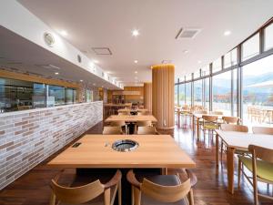 a restaurant with tables and chairs and windows at さめうら荘レイクサイドホテル in Tosa