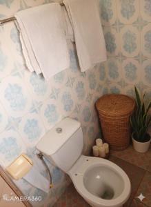 een badkamer met een toilet en handdoeken aan de muur bij ASSOUKA Eco-Village du lac Nokoué in Abomey-Calavi