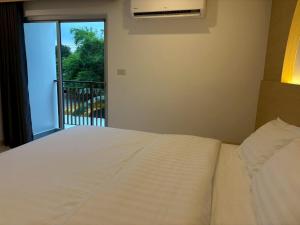 a bedroom with a bed and a balcony at Luna Resident in Ban Bang Phai