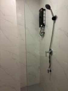 a shower in a bathroom with a phone on the wall at Luna Resident in Ban Bang Phai