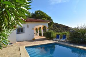 a house with a swimming pool and two blue chairs at Villa La Frasca with private Pool in Corumbela