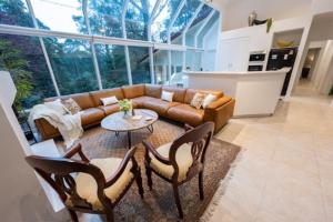 a living room with a couch and a table and chairs at Idaway Retreat in Olinda +13 photos