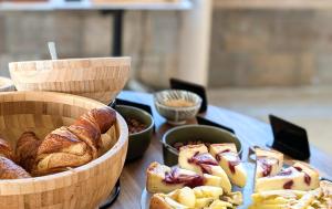 a table with baskets of bread and pastries on it at Hotel Medium Claramar in Platja  d'Aro