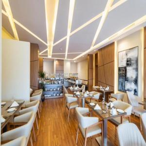 een eetkamer met tafels en witte stoelen bij Sunday Luxury Central formerly Anan hotel in Riyad