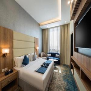 a hotel room with a large bed and a flat screen tv at Sunday Luxury Central formerly Anan hotel in Riyadh