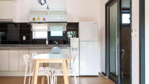 a kitchen with a table and a refrigerator at Gyeongju Hiltopia Kids Pool Villa in Gyeongju
