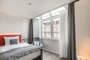 a bedroom with a bed and a large window at Garner Hotel Wiesbaden City by IHG in Wiesbaden +32 photos