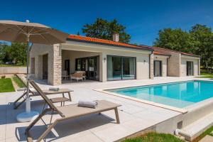 eine Villa mit Swimmingpool und Sonnenschirm in der Unterkunft Villa Vista Verde in Majkusi