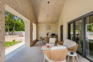 ein offenes Wohnzimmer mit einem Sofa und Stühlen in der Unterkunft Villa Vista Verde in Majkusi