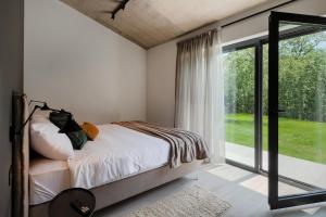 ein Schlafzimmer mit einem Bett und einem großen Fenster in der Unterkunft Villa Vista Verde in Majkusi + 34 Fotos