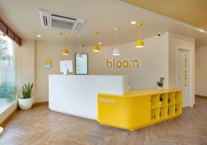 a waiting room with a yellow and white counter at Bloom Hotel - Whitefield in Bangalore