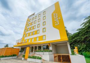 a hotel with a yellow and white building at Bloom Hotel - Whitefield in Bangalore