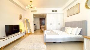 a bedroom with a bed and a flat screen tv at Modern studio with Beach and Pool in Al Marjan Island in Ras al Khaimah