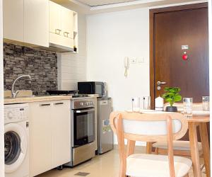 a kitchen with a table and a sink and a dishwasher at Modern studio with Beach and Pool in Al Marjan Island in Ras al Khaimah