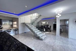 a living room and kitchen with a staircase in a house at The Coastal Charm Villa in Ballito