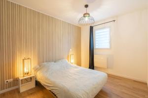 een slaapkamer met een groot bed en een raam bij L'instant fleuri in Saint-Hippolyte