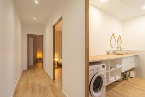 een witte wasruimte met een wasmachine en droger bij L'instant fleuri in Saint-Hippolyte