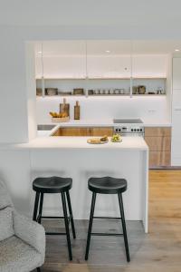 a kitchen with two stools and a counter with a stove at Waldmaise in Hayingen