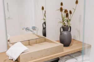 a bathroom with a sink and a vase with flowers at Waldmaise in Hayingen