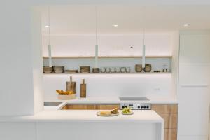 a kitchen with white cabinets and a white stove top oven at Waldmaise in Hayingen +26 photos