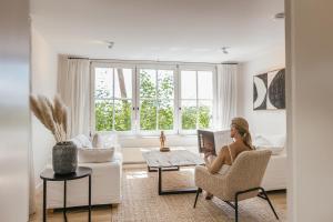 a woman sitting in a chair in a living room at Waldmaise in Hayingen