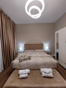 a bedroom with a large bed with two towels on the floor at Perla Toscana - Relax a 30 km da Firenze in Podere Modello