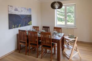 a dining room with a wooden table and chairs at Naturpur Ferienhaus in Friedrichsbrunn
