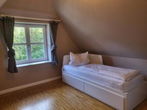 a bed in a room with a window at Böhler Haubarg Böhler Stuv 7 in Böhl