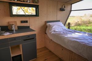 Un pequeño dormitorio con una cama en una casa diminuta. en Sleep Space 2 - Green&Tiny Spot Osterwieck Birkenmühle, en Osterwieck