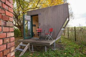 Una pequeña casa con dos sillas rojas y una mesa. en Sleep Space 2 - Green&Tiny Spot Osterwieck Birkenmühle, en Osterwieck