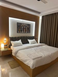a bedroom with a large bed with white sheets at Amara heaven in Lucknow