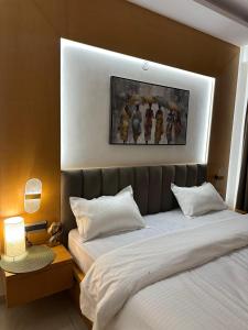 a bedroom with two beds and a painting on the wall at Amara heaven in Lucknow