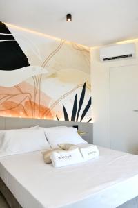 Un dormitorio con una cama blanca con un cuadro en la pared. en Moddissi Charme camere, en Trappola