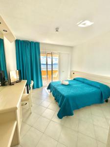 a bedroom with a blue bed and a desk at Hotel Miralonga in La Maddalena