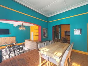 a dining room with a wooden table and chairs at BIM Backpackers In Muizenberg in Muizenberg