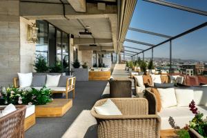 an outdoor patio with chairs and tables and windows at Stars by Castor & Pollux in Tbilisi City