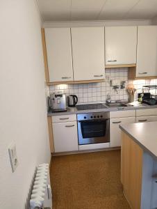 a kitchen with white cabinets and a stove top oven at 2 Zimmer Apartement mit Balkon bei Düsseldorf in Erkrath