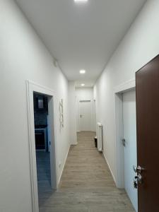 an empty hallway with white walls and a hallway with doors at Da Vinci Apartment in Lavezzola