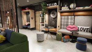 um quarto com um sofá e cadeiras numa loja em Moxy Zurich em Zurique