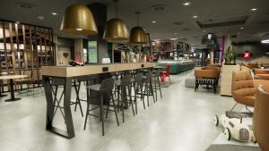 um restaurante com um bar com cadeiras e mesas em Moxy Zurich em Zurique