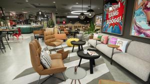 uma loja com sofás, mesas e cadeiras em Moxy Zurich em Zurique mais 22 fotografias