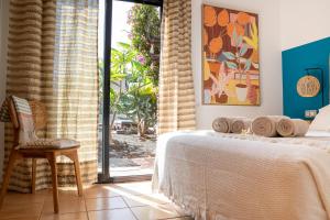 a bedroom with a bed and a sliding glass door at Alma Ventura House - Majanicho in Majanicho +73 photos