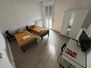 a small room with two beds and a table at Da Vinci Apartment in Lavezzola