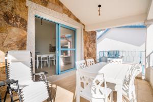 een eetkamer met een witte tafel en stoelen bij Girasole in La Caletta