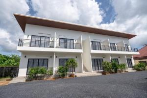 une maison blanche avec des fenêtres noires dans l'établissement Uncle Toy, à Ban Riang