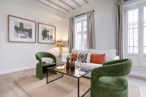 ein Wohnzimmer mit einem Sofa und zwei grünen Stühlen in der Unterkunft Genteel Home Patrocinio Cádiz in Cádiz