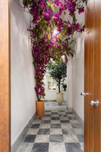 ein Flur mit Blumen an der Wand und einer Tür in der Unterkunft Genteel Home Patrocinio Cádiz in Cádiz