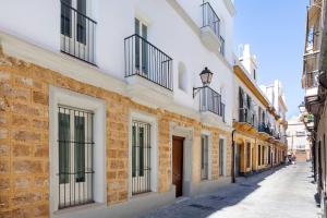 eine Gasse in einer Stadt mit weißen Gebäuden in der Unterkunft Genteel Home Patrocinio Cádiz in Cádiz + 44 Fotos