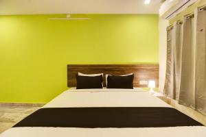 Maula AliにあるHotel O Raga Staysの緑の壁と大きなベッドのある寝室
